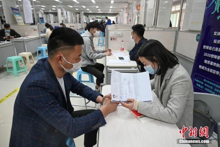 4月14日，招聘者在查看求職者簡歷。<a target='_blank'  data-cke-saved- >中新社</a>記者 王剛 攝