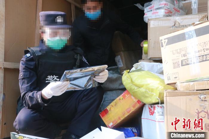 圖為勐康邊檢站民警在對(duì)快遞運(yùn)輸車輛進(jìn)行例行檢查?！钐?攝