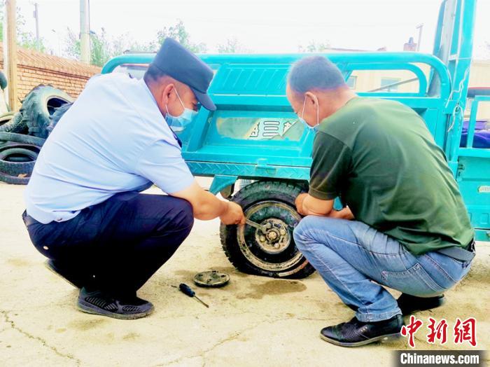 賽旦與民警共同維修三輪摩托車?！∫懒窘?攝