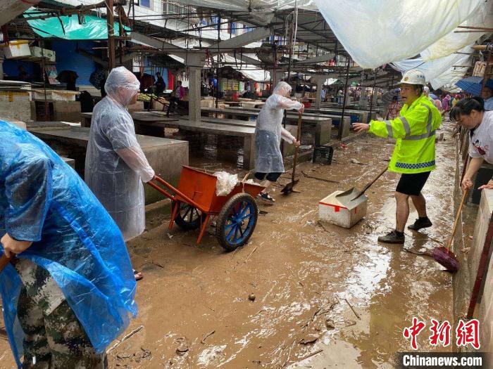 圖為7月26日，暴雨引發(fā)的洪水過境后，重慶萬州區(qū)分水鎮(zhèn)政府干部職工及志愿者清掃淤泥和垃圾?！　≈貞c萬州區(qū)委宣傳部供圖 攝
