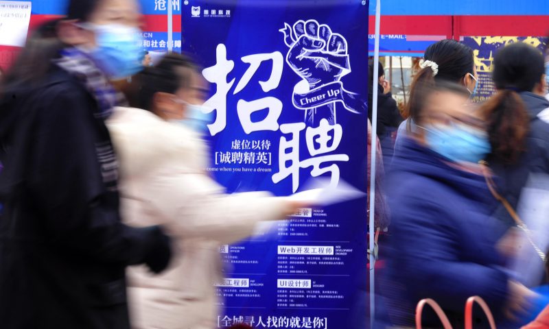 求職者從一家招聘企業(yè)的廣告牌前走過。新華社發(fā)（苑立偉 攝）